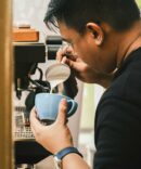 Barista pouring milk on cup